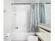 Bright bathroom featuring a tub with white tile surround and striped shower curtain at 6043 44Th E Ct, Bradenton, FL 34203