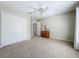 Carpeted bedroom featuring a ceiling fan, closet and side table with a lamp at 6043 44Th E Ct, Bradenton, FL 34203