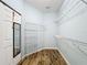 Walk-in closet with wood flooring, shelving, door mirror, and ample storage space at 6043 44Th E Ct, Bradenton, FL 34203