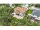 Aerial view capturing the home's layout, screened in lanai, and stone patio surrounded by lush greenery at 6043 44Th E Ct, Bradenton, FL 34203