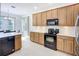 Well-lit kitchen featuring updated appliances and wooden cabinetry at 6043 44Th E Ct, Bradenton, FL 34203