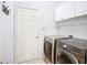Laundry room featuring modern appliances, upper cabinets for storage, and tile flooring at 6043 44Th E Ct, Bradenton, FL 34203