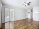 Open-concept living room features wood floors, sliding glass doors to the lanai and access to other rooms at 6043 44Th E Ct, Bradenton, FL 34203