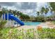 Community swimming pool and slide surrounded by palm trees and lounge chairs for relaxing at 6043 44Th E Ct, Bradenton, FL 34203