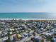 Aerial view showcasing a home's proximity to a Gulf Coast beach and the bright blue ocean at 616 Fern St, Anna Maria, FL 34216