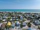A captivating aerial view of a beach community highlighting a modern home with a pool near the ocean at 616 Fern St, Anna Maria, FL 34216