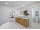 Bright bathroom featuring a large, lighted mirror, double sink vanity, and a glimpse into the main bedroom at 616 Fern St, Anna Maria, FL 34216