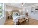 Beautiful bedroom with hardwood floors, designer accent wall, and a bench at the end of the bed at 616 Fern St, Anna Maria, FL 34216