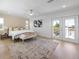 A spacious bedroom with a balcony, a decorative accent wall, a ceiling fan, and hardwood floors at 616 Fern St, Anna Maria, FL 34216