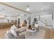 Open-concept living area with modern furnishings, hardwood floors, and seamless flow into kitchen at 616 Fern St, Anna Maria, FL 34216