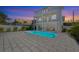 A luxurious pool area in a modern two-story home with an outdoor living space at dusk at 616 Fern St, Anna Maria, FL 34216
