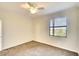 Cozy bedroom with plush carpet, ceiling fan, and view of the backyard at 6509 Grand Estuary Trl # 201, Bradenton, FL 34212