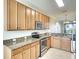 Well-lit kitchen boasts granite countertops, stainless steel appliances and ample maple cabinets at 6509 Grand Estuary Trl # 201, Bradenton, FL 34212