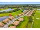 Aerial view of a community with villas, lake, and golf course with lush green landscaping at 6923 Grand Estuary Trl # 101, Bradenton, FL 34212