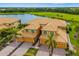 Aerial view of the community with lush landscaping, a lake, and tile-roofed townhomes at 6923 Grand Estuary Trl # 101, Bradenton, FL 34212