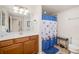 Bathroom featuring wood vanity, mirror, decorative shower curtain, and tile flooring at 6923 Grand Estuary Trl # 101, Bradenton, FL 34212
