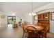 Dining area with wood table, chairs, hutch, tile floors, and open to a living room at 6923 Grand Estuary Trl # 101, Bradenton, FL 34212