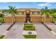 Aerial view of the home featuring tropical landscaping, tile roof, and paver driveway at 6923 Grand Estuary Trl # 101, Bradenton, FL 34212