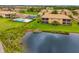 Exterior shot of a condo overlooking a pond and community pool with lots of green grass at 6923 Grand Estuary Trl # 101, Bradenton, FL 34212
