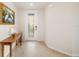 Foyer with wood table, decorative glass front door, and neutral tile flooring at 6923 Grand Estuary Trl # 101, Bradenton, FL 34212