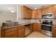 Well-equipped kitchen featuring stainless steel appliances, granite countertops, and tile backsplash at 6923 Grand Estuary Trl # 101, Bradenton, FL 34212