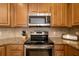 Close up of modern kitchen featuring stainless steel appliances, granite countertops, and tiled backsplash at 6923 Grand Estuary Trl # 101, Bradenton, FL 34212