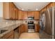 Modern kitchen featuring stainless steel appliances, granite countertops, and tiled backsplash at 6923 Grand Estuary Trl # 101, Bradenton, FL 34212