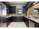Well-equipped kitchenette with dark wood cabinets, stainless steel appliances and marble countertops in meeting room at 6923 Grand Estuary Trl # 101, Bradenton, FL 34212
