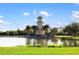 Picturesque view of a lighthouse surrounded by water, lush greenery, and a bright blue sky with clouds at 6923 Grand Estuary Trl # 101, Bradenton, FL 34212