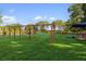 Community playground with swings and play equipment on a well maintained lawn and trees at 6923 Grand Estuary Trl # 101, Bradenton, FL 34212