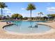 Community pool featuring a shallow water area, lounge chairs, and lush landscaping at 6923 Grand Estuary Trl # 101, Bradenton, FL 34212