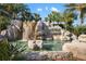 Scenic water feature with cascading waterfall, rock formations, and lush landscaping at River Strand community at 6923 Grand Estuary Trl # 101, Bradenton, FL 34212