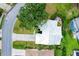 Aerial view of a home with lush landscaping, a serene backyard pond, and a perfectly manicured lawn at 6929 Stetson Street Cir, Sarasota, FL 34243