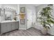 Elegant bathroom with gray cabinets, wood-look flooring, and a soaking tub at 6929 Stetson Street Cir, Sarasota, FL 34243