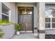 Elegant front door with sidelights, transom window, and decorative potted plant creates a welcoming entryway at 6929 Stetson Street Cir, Sarasota, FL 34243