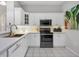 Bright kitchen features white cabinets, stainless steel appliances and a modern faucet at 6929 Stetson Street Cir, Sarasota, FL 34243