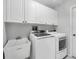 Well-lit laundry room with modern white washer and dryer and plenty of storage at 6929 Stetson Street Cir, Sarasota, FL 34243