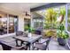 Cozy screened patio with a dining table and lush landscaping view at 6929 Stetson Street Cir, Sarasota, FL 34243