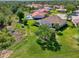Lovely aerial view of a home with a screen enclosed pool, set amongst other similar houses in a verdant neighborhood at 7302 Dunes Ct, Bradenton, FL 34202