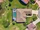 Aerial view showcases the home, screen-enclosed pool, tile roof and well-manicured lawn at 7302 Dunes Ct, Bradenton, FL 34202