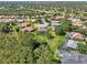 Expansive aerial view of the property, showcasing its large lot, screened-in pool, and lush landscaping in a serene neighborhood at 7302 Dunes Ct, Bradenton, FL 34202