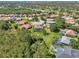 Aerial view of a home surrounded by lush greenery, mature trees, and well-maintained lawns in a residential neighborhood at 7302 Dunes Ct, Bradenton, FL 34202