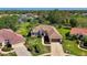 Aerial view of a single-story home with a tile roof, verdant landscaping, and a pristine lawn at 7302 Dunes Ct, Bradenton, FL 34202