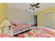 Comfortable bedroom with hardwood floors, two beds, closet and yellow accent wall at 7302 Dunes Ct, Bradenton, FL 34202