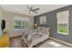 Bedroom with plenty of natural light featuring a comfortable bed, ceiling fan, and hardwood floors at 7302 Dunes Ct, Bradenton, FL 34202