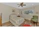 Cozy bedroom featuring a comfortable bed, ceiling fan, and large window with a view of the outdoors at 7302 Dunes Ct, Bradenton, FL 34202