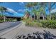 View of the Clubhouse entrance with a porte cochere and tropical landscaping at 7302 Dunes Ct, Bradenton, FL 34202