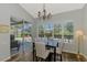 Bright dining area with a large window, chandelier, and a view of the pool at 7302 Dunes Ct, Bradenton, FL 34202