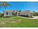 Beautiful single-story home featuring lush landscaping, a well-manicured lawn, and a tile roof at 7302 Dunes Ct, Bradenton, FL 34202