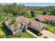Aerial view capturing the home's manicured lawn, landscaping, and charming tile roof at 7302 Dunes Ct, Bradenton, FL 34202